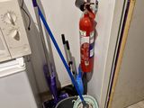 a fire extinguisher next to a bucket of water and a mop