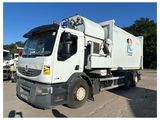 un camion-poubelle blanc garé sur un parking