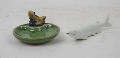a small figurine of a cat and a fish in a bowl
