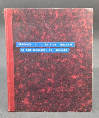 an old book with a red cover sitting on top of a table