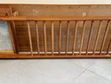 a wooden crib with a magazine rack on it