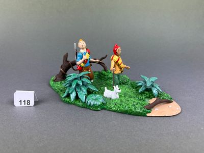 a miniature figurine of a man and a dog on a small island