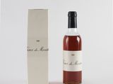 une bouteille de vin posée à côté d'une boîte sur une surface blanche