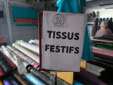 a sign that says tiss festifs hanging from a rack