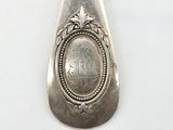 a silver spoon with a picture on it on a white surface