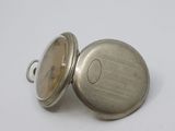 a close up of a silver pocket watch on a white surface