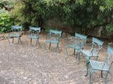 six chairs and a table in the middle of a garden