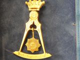a gold medal with a crown on top of it