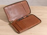 wallet on a wooden table with a pen in it
