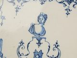 a blue and white plate with a picture of a woman on it