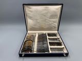 an open case with silverware in it sitting on a table