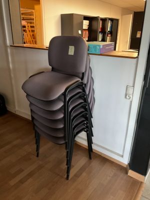 une pile de chaises empilées les unes sur les autres dans une pièce