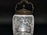un bocal en verre ancien muni d'un couvercle et d'une poignée en métal