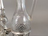 a silver plate with a glass pitcher and a candle holder on it