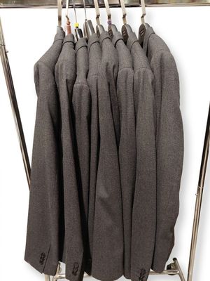 une pile de costumes suspendus à un portant