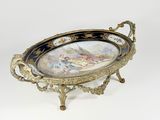 a decorative tray with a painting on it on a stand