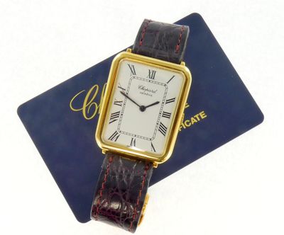 une photo d'une montre-bracelet en or posée sur une carte bleue