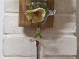 a vase with flowers in it hanging on a wall