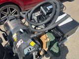 a red car parked next to a pile of assorted items