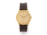 a gold plated wrist watch with brown leather strap