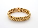 un bracelet à chaîne en or avec un fermoir sur fond blanc