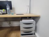 an image of a desk with drawers and a computer