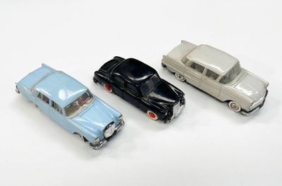 trois petites voitures assises l'une à côté de l'autre sur une surface blanche