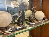 une étagère en verre sur laquelle sont posées quelques statues, dans une pièce