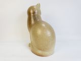 a brown cat statue sitting on a white surface