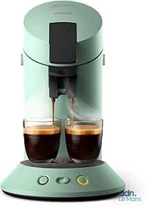 two cups of coffee being poured into a coffee machine