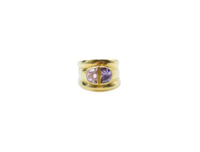 a gold ring with a purple stone in the center