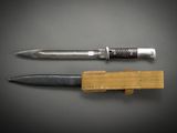 two knives and a knife holder on a black surface