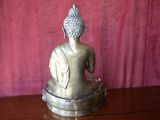 a statue of a buddha sitting on top of a wooden table
