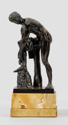 une image représentant une statue en bronze d'un homme penché sur un rocher