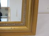 a picture of a gold framed mirror on the wall