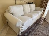 a white couch in a living room with a rug on the floor