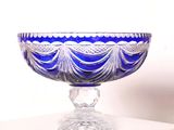 un saladier en verre bleu posé sur une table blanche