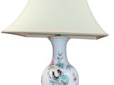an image of a white table lamp with a bird and flowers on it