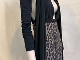 Le mannequin porte une jupe à imprimé léopard et un cardigan noir.