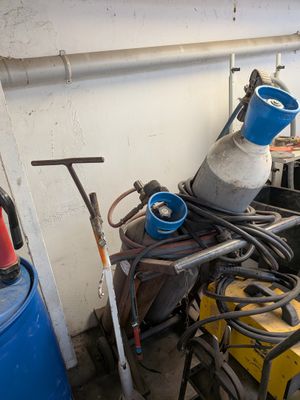 un seau bleu posé sur une table, à côté d'une pile d'outils