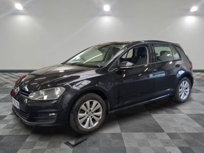 Une Volkswagen Golf noire est garée sur un sol à damier.