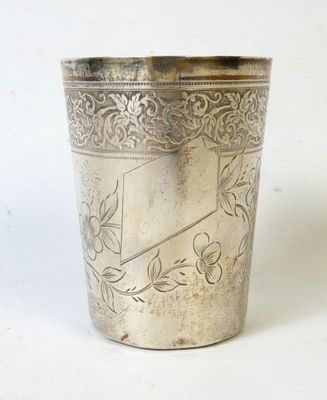 une tasse en argent antique avec un motif floral sur le bord
