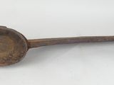 an old wooden spoon with a metal handle on a white surface