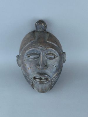 une image montrant un gros plan d'un masque métallique posé sur une surface blanche