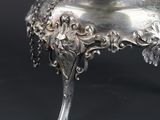 an antique silver plate with a flower design on top of it