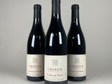 trois bouteilles de vin rouge posées sur une table