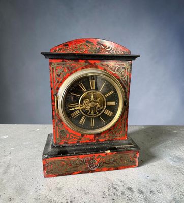 une horloge rouge et noire posée sur une table