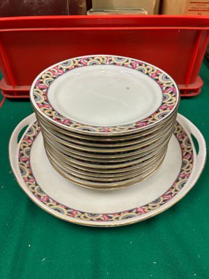 une pile d'assiettes posée sur une table, à côté d'un récipient rouge