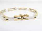 a close up of a gold and silver bracelet on a white surface
