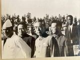a group of men that are standing together in front of a building